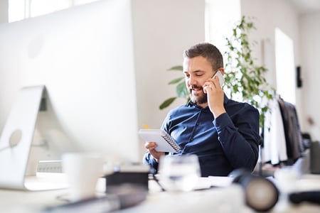 Mann telefoniert und kümmert sich um Sales Enablement