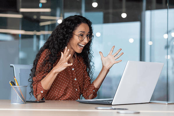 Hispanisch aussehende Frau freut sich ueber Ihren Erfolg beim Social Selling